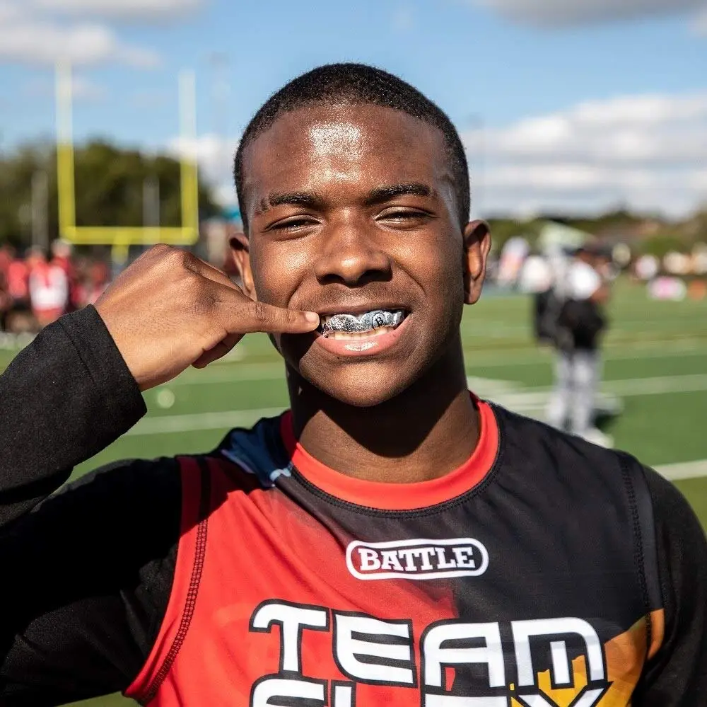 Can you wear grillz while playing sports? Gold grillz beside a sports mouthguard