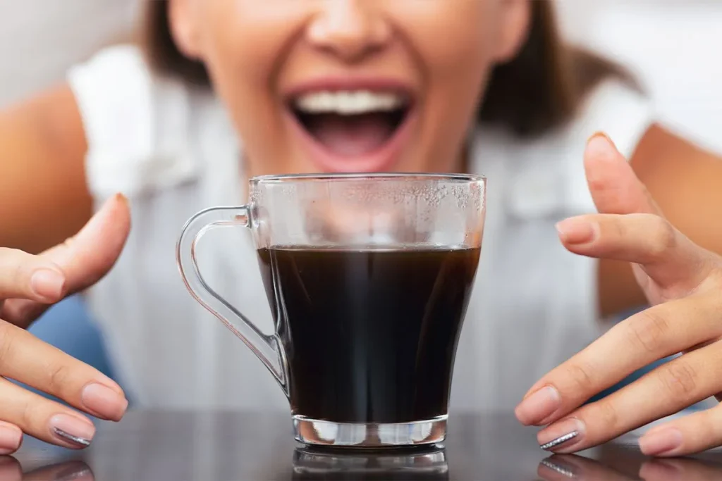 Drinking coffee with grillz: gold grillz and a coffee cup