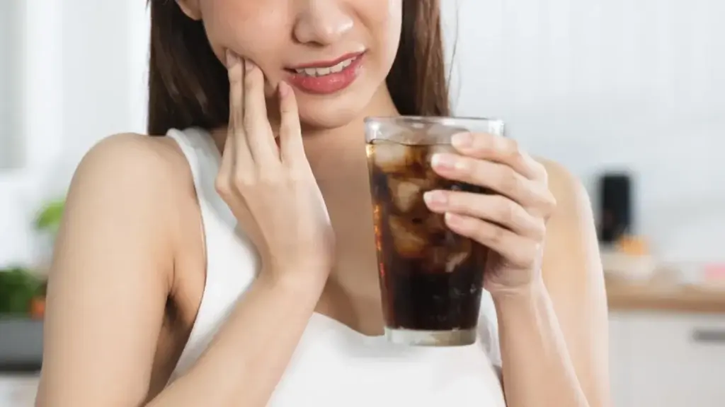 Drinking coffee with grillz: gold grillz and a coffee cup
