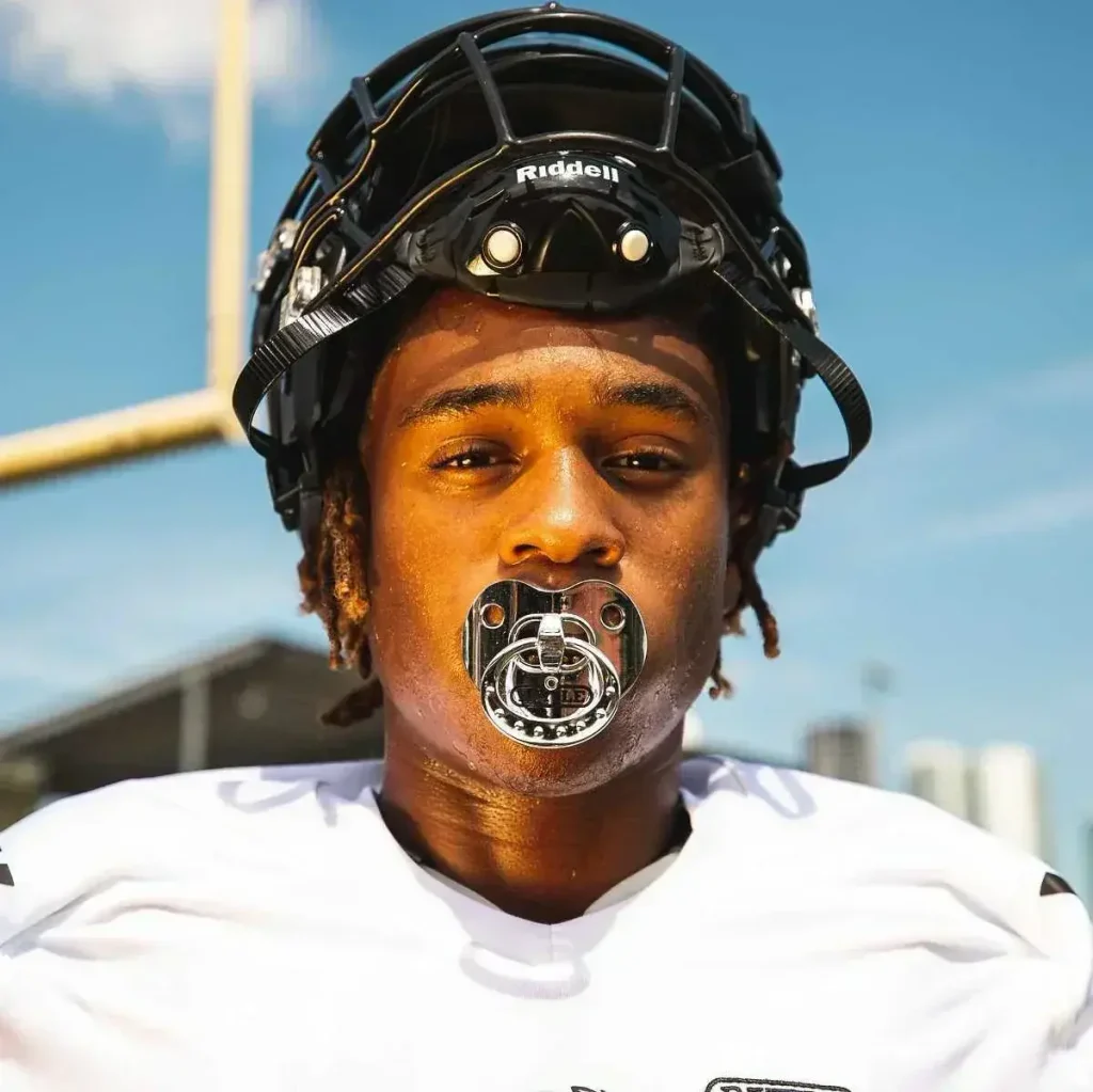 Can you wear grillz while playing sports? Gold grillz beside a sports mouthguard