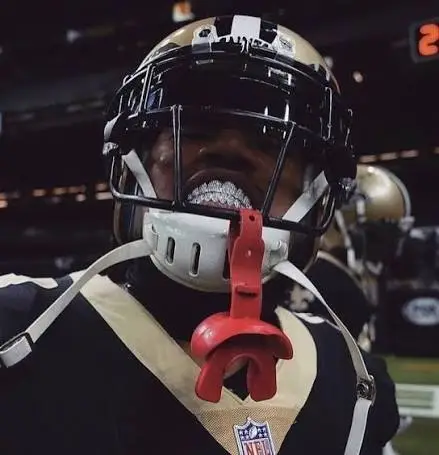 Can you wear grillz while playing sports? Gold grillz beside a sports mouthguard